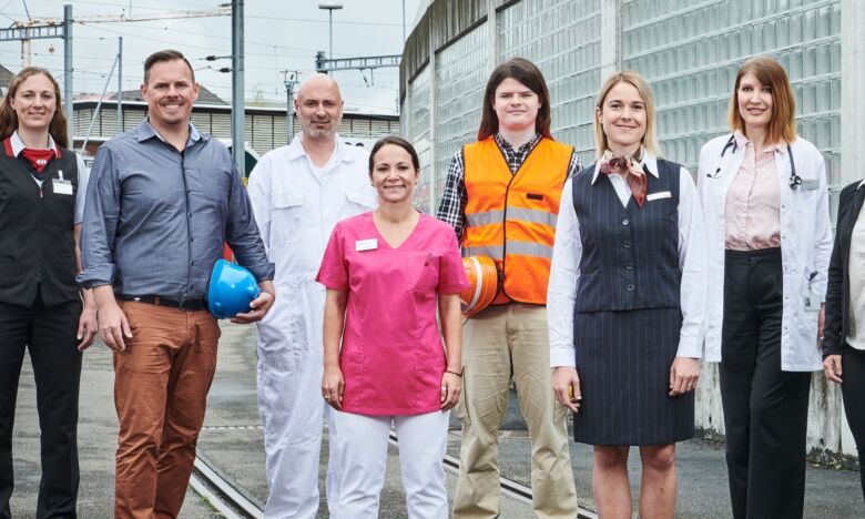 Personen aus verschiedenen Berufskategorien stehen draussen zusammen