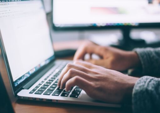 Hände tippen auf Laptop