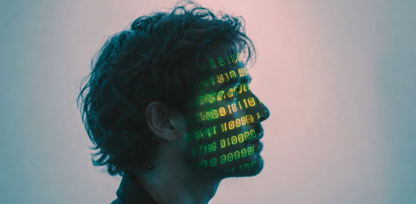 Profil einer Person mit auf das Gesicht projiziertem Binärcode, symbolisch für künstliche Intelligenz, Digitalisierung und Daten im Gesundheitskontext.