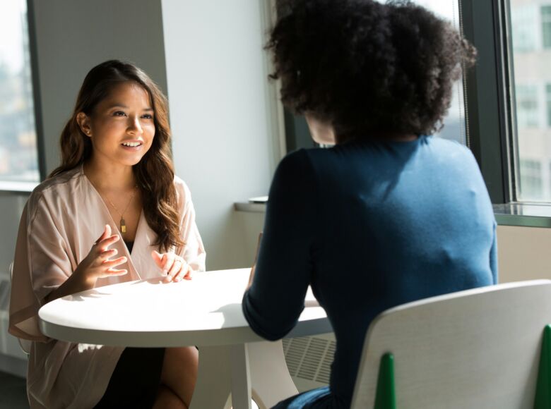 Professionelles Coaching-Gespräch zwischen zwei Frauen für Beratung, persönliche Entwicklung und neue Perspektiven im Gesundheitsbereich.